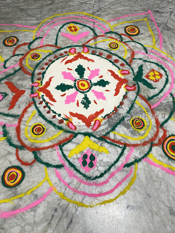 为庆祝排灯节而设计的gulal rangoli图案，用彩色粉末涂料在灰色瓷砖地板上绘制的图案，庆祝灯节，高架视野